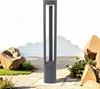 A modern gray outdoor lamp stands in a garden setting with rocks and gravel. Produktbild-Vorschau