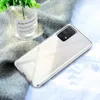 A clear phone case is shown on a textured gray and white fabric background, with a small glass vase containing green plants in the upper left corner. Podgląd zdjęcia produktu