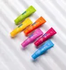 A collection of colorful toothpaste tubes arranged diagonally on a white and gray striped background. Anteprima dell’immagine prodotto