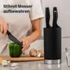 A person is chopping a green bell pepper on a wooden cutting board, with a knife block and mushrooms nearby. Produktbild-Vorschau