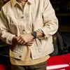 A person wearing a watch leans against a red car. Voir les images du produit