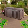 A brown storage box sits on a wooden deck next to a pond and garden. Podgląd zdjęcia produktu