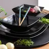 A set of black ceramic dishes with chopsticks and some vegetables. Náhled obrázku produktu