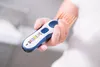 A hand holds a cordless hair clipper with a comb attachment. Produktbild-Vorschau