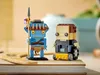 Two LEGO BrickHeadz figures, one resembling an Avatar character and the other a person in a wheelchair, are displayed on a wooden surface. Náhled obrázku produktu
