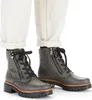 A close-up shot of a pair of women's gray lace-up boots with side zippers, worn with white cuffed jeans. Produktbild-Vorschau