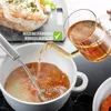 A glass pitcher pouring liquid into a white pot with a whisk inside, with a piece of cooked meat and vegetables in the background. Náhľad obrázku produktu
