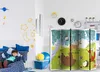 A child is lying on a bed in a room decorated with space-themed wall decals. A folding screen with a forest animal illustration is set up in the foreground. Náhľad obrázku produktu