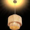 A pendant lamp with a two-tiered, woven shade made of natural fibers, suspended from a ceiling mount. Produktbild-Vorschau
