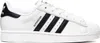 A side view of a white Adidas Superstar sneaker with black stripes and detailing. Voir les images du produit
