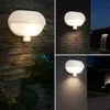 Collage of outdoor wall lights in various settings at night. Produktbild-Vorschau