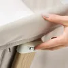 A close-up shot of a hand adjusting a latch on a baby crib. Produktbild-Vorschau
