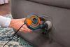 A hand holding an electric air pump connected to an air mattress. Produktbild-Vorschau