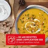 A bowl of soup with a side of cream and a wooden spoon on a wooden table. Voir les images du produit