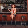 A woman sits on a stool at a bar. Produktbild-Vorschau