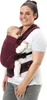 A woman is wearing a baby carrier with a baby in it, against a white background. Produktbild-Vorschau