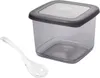A square plastic food storage container with a dark gray lid and a clear plastic spoon next to it, isolated on a white background. Anteprima dell’immagine prodotto