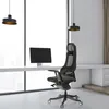 An office chair and desk setup in a modern office with large windows. Produktbild-Vorschau