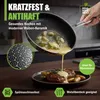 A hand is pouring sauce from a frying pan onto a steak on a plate, with a close-up of the pan's interior texture. Produktbild-Vorschau