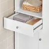 A close-up view of a white bathroom cabinet with an open drawer revealing towels and a hairbrush. Produktbild-Vorschau