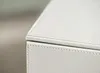 A close-up view of the corner of a white leather storage box. Voir les images du produit