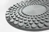 A close-up, angled view of a gray twisting disc with raised nubs. Produktbild-Vorschau