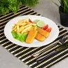 A plate of food, including fish sticks and french fries, is presented on a placemat. Náhľad obrázku produktu