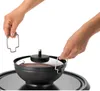 Eine Person hebt mit einem Metallwerkzeug den heißen Deckel sicher vom Unold Raclette Multi 4 in 1 a Produktbild-Vorschau