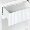 A close-up view of an open drawer on a white nightstand. Produktbild-Vorschau