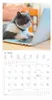 A cat sitting in front of a laptop, with a calendar page below. Produktbild-Vorschau