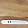 A white LED light bar with USB ports and a power button is placed on a wooden surface. Voir les images du produit