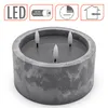 A concrete-look LED candle with three wicks, shown from a slightly elevated angle against a white background. Informational icons are displayed in the top corners. Anteprima dell’immagine prodotto