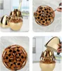 Collage of images showing a golden cutlery set in a decorative holder. Produktbild-Vorschau