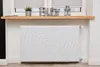 A white radiator cover with a heart design is placed in front of a window with blinds. Produktbild-Vorschau
