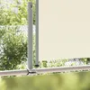 A close-up view of a cream-colored retractable side awning attached to a railing, with greenery in the background. Anteprima dell’immagine prodotto