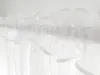 A close-up view of white sheer curtains hanging on a rod. Produktbild-Vorschau