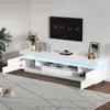 A modern white TV stand with LED lighting, displaying a television and decorative items. Podgląd zdjęcia produktu