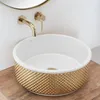 A close-up shot of a decorative sink with gold accents, mounted on a wall with a gold faucet. Náhled obrázku produktu