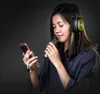 A young woman wearing headphones and holding a microphone and a smartphone. Anteprima dell’immagine prodotto