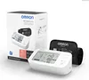 The image shows the Omron M6 Comfort AFib upper arm blood pressure monitor and its packaging. Produktbild-Vorschau