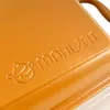 A close-up view of an orange cast iron pot with embossed text. Podgląd zdjęcia produktu