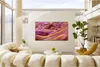 A modern living room with a large TV displaying abstract art, a comfortable sectional sofa, a yellow accent chair, and a potted plant. Produktbild-Vorschau