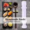 A flat lay of sushi and a sushi-making tool on a textured gray surface. Náhled obrázku produktu