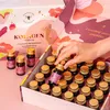 A hand is reaching into a box of small bottles, likely a dietary supplement, with decorative packaging. Produktbild-Vorschau