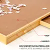 Close-up view of a wooden puzzle table with drawers, showing puzzle pieces on the surface. Produktbild-Vorschau
