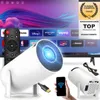 A collage of a mini projector, remote control, smartphone, and cables, with a TV screen in the background displaying a streaming service interface. Produktbild-Vorschau