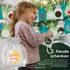A young girl is looking at a string of Christmas advent calendar bags. Produktbild-Vorschau