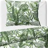A close-up view of a pillow and duvet cover with a tropical leaf pattern. Produktbild-Vorschau