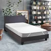A mattress protector on a bed in a room with bookshelves. Anteprima dell’immagine prodotto