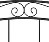 Close-up of the ornate scrollwork on the headboard of a black metal bed frame. Podgląd zdjęcia produktu